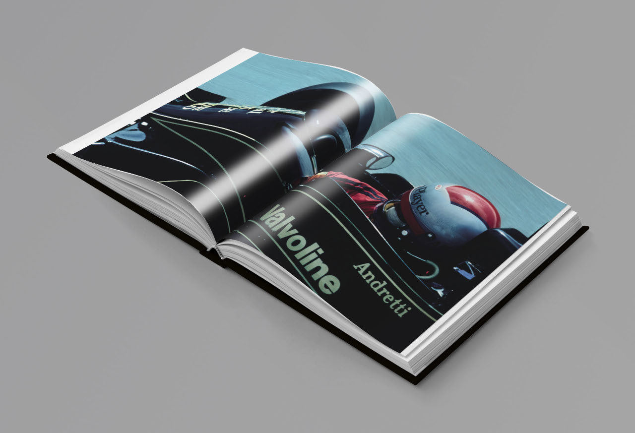Open racing photo book with blue car spread and bold 'rev' lettering