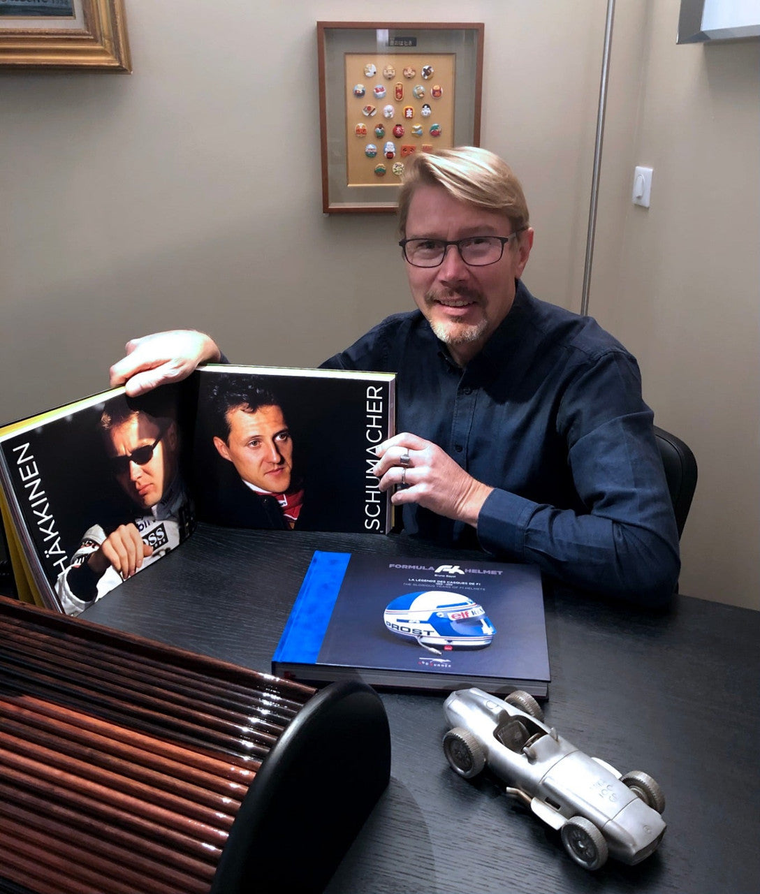 Helmet-themed book held open on a table with a blue book resting beside it.