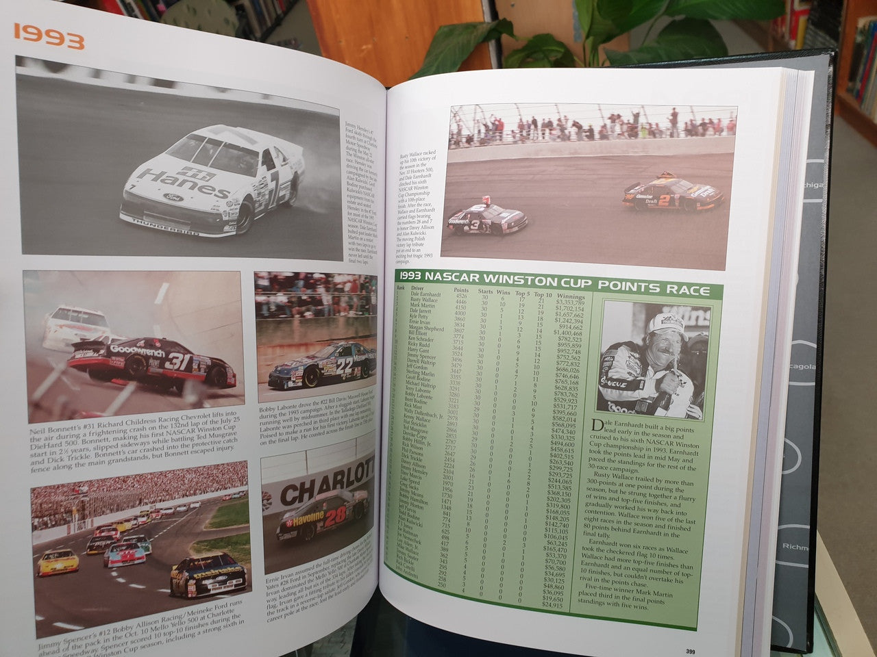 Hardcover NASCAR history book open to race points page with photos and green text