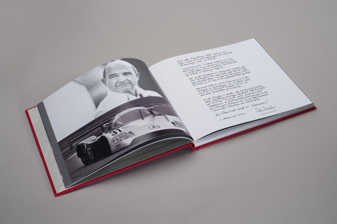 Open hardcover photo book with black-and-white racer photo and printed text
