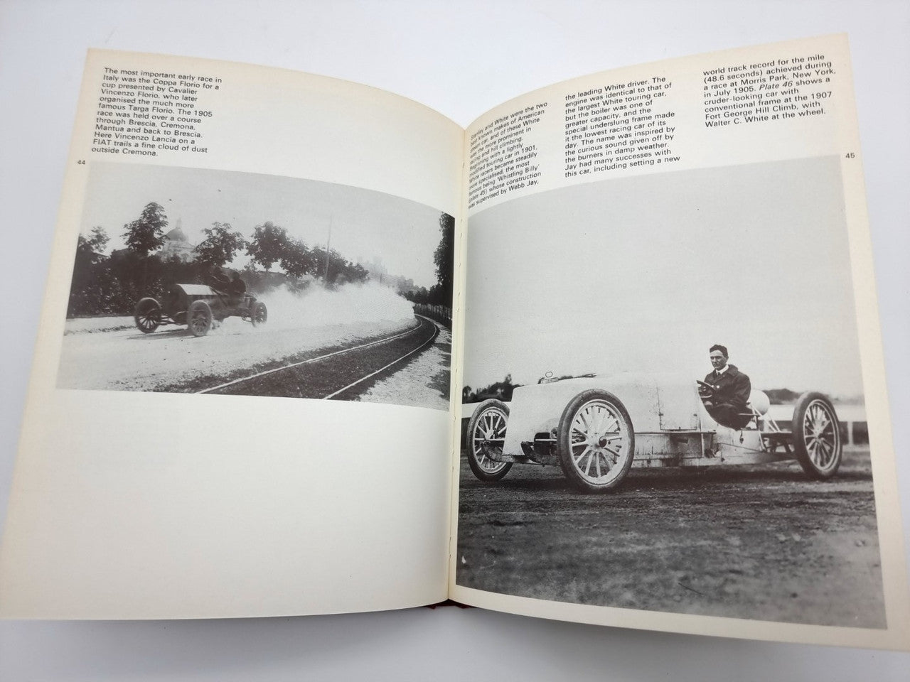 Open hardcover book with black-and-white car photos on left and right pages