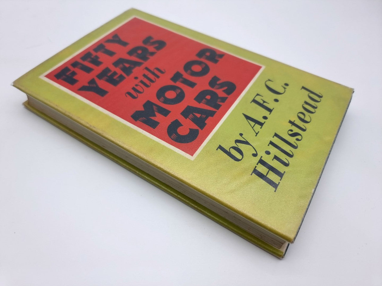 Book cover with green border, red title letters, and author name on yellow background.