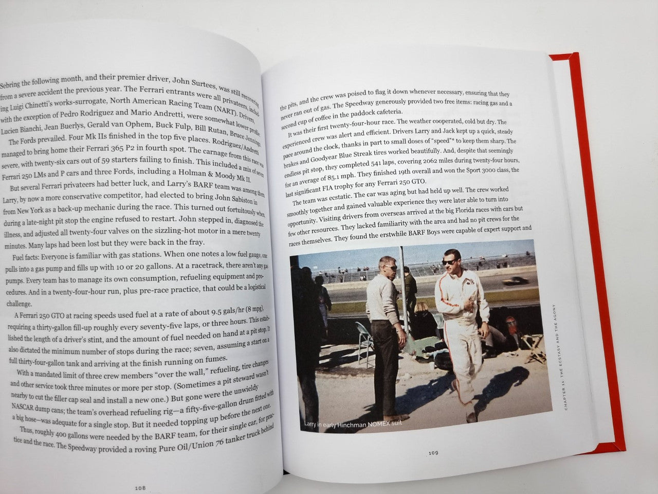 Hardcover book open to text with a trackside photo of two men standing outdoors