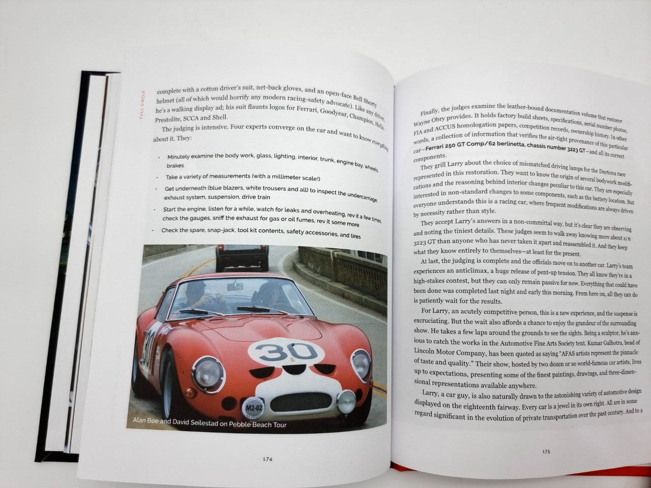 Hardcover book open to a spread with a front view photo of a red race car and paragraphs
