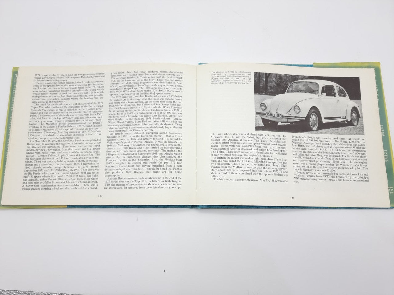 Volkswagen Beetle guidebook open, car photo page with dense text