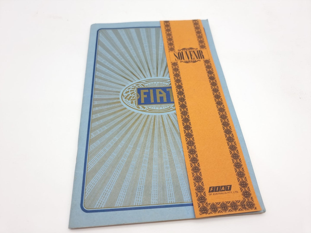 Fiat souvenir catalogue reprint, blue cover with Fiat emblem and orange decorative strip