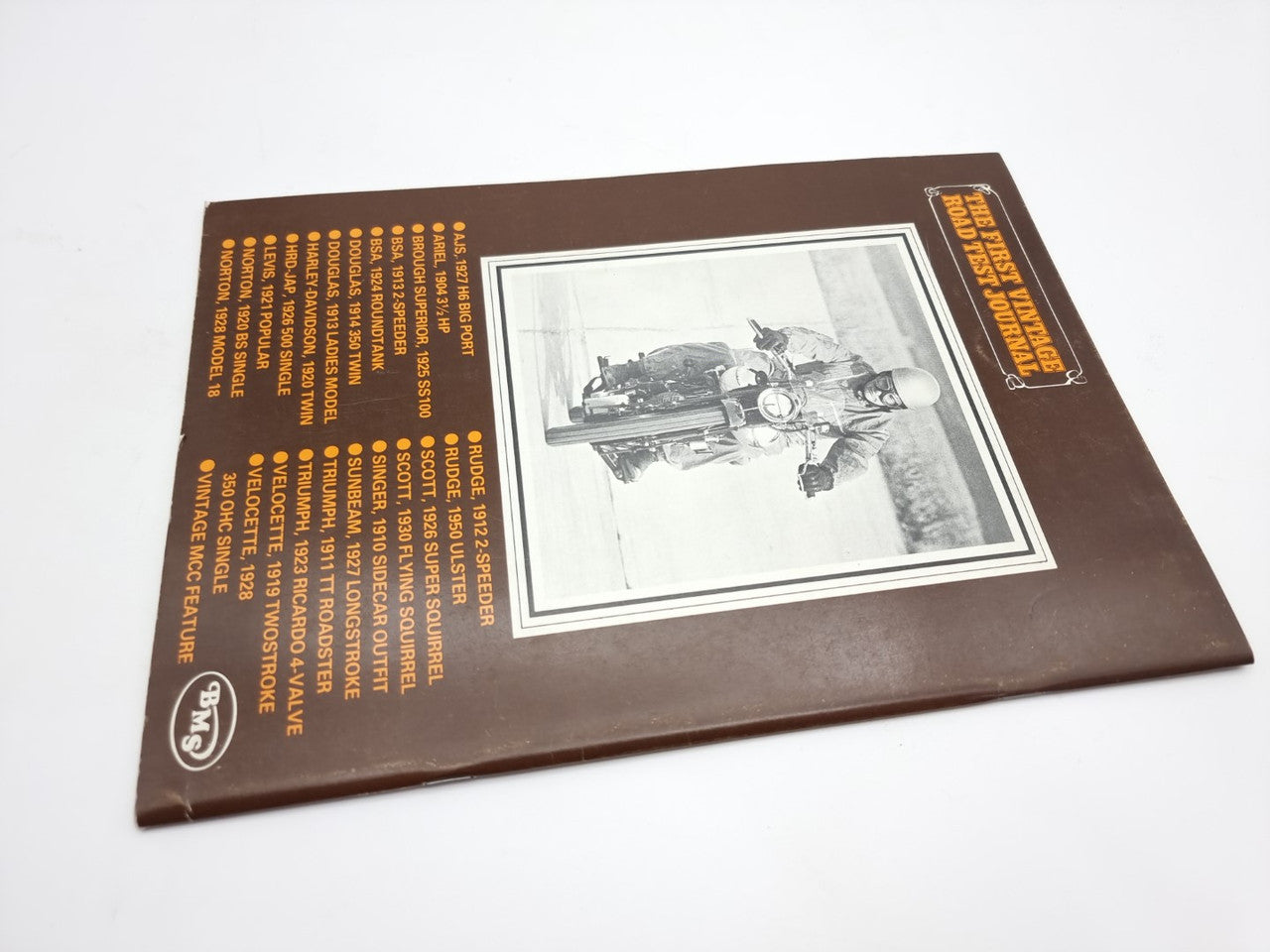 Vintage road test journal back cover with motorcycle photo and orange text block
