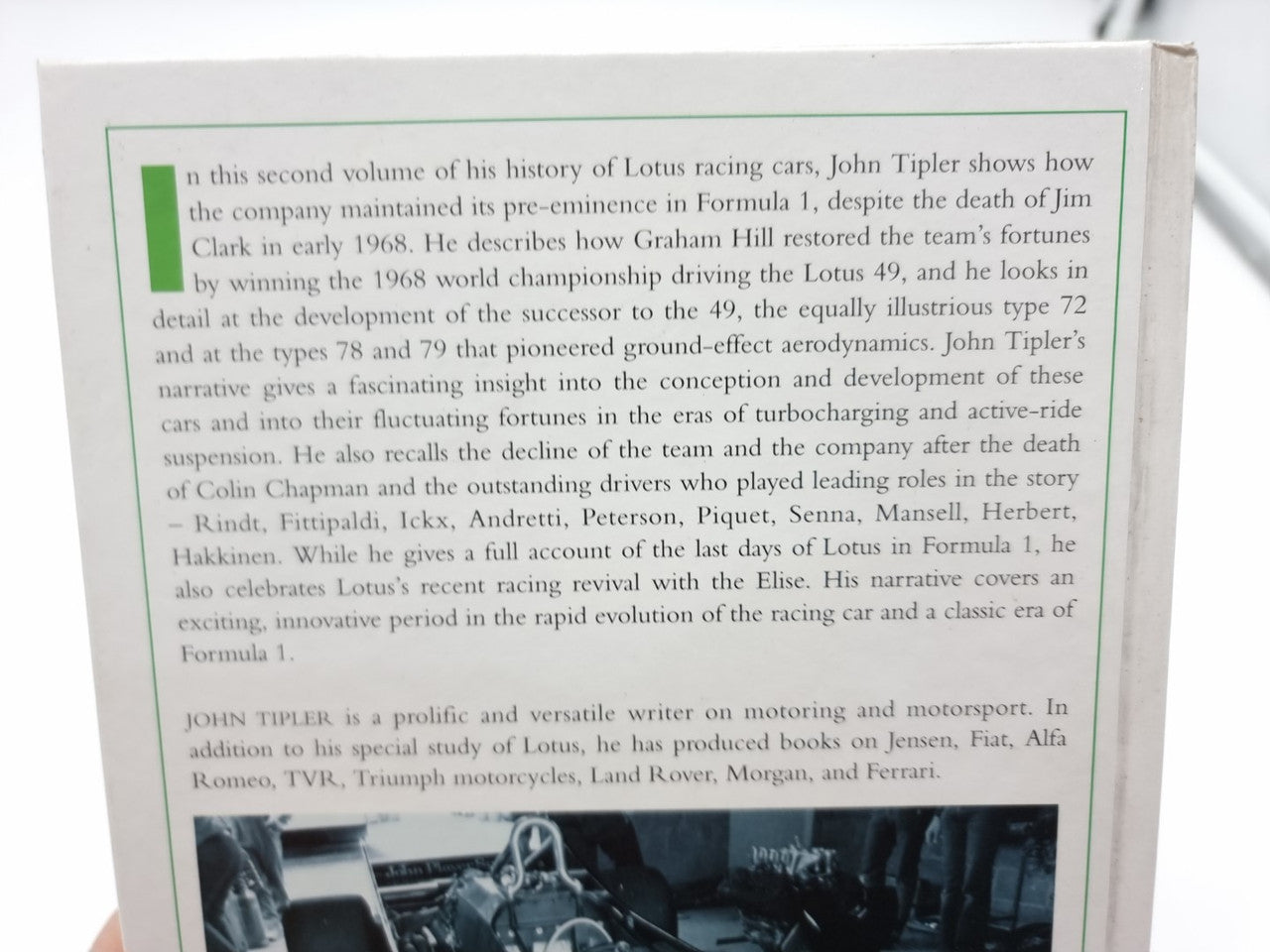 Open auto racing history book page with dense text and a small black-and-white photo