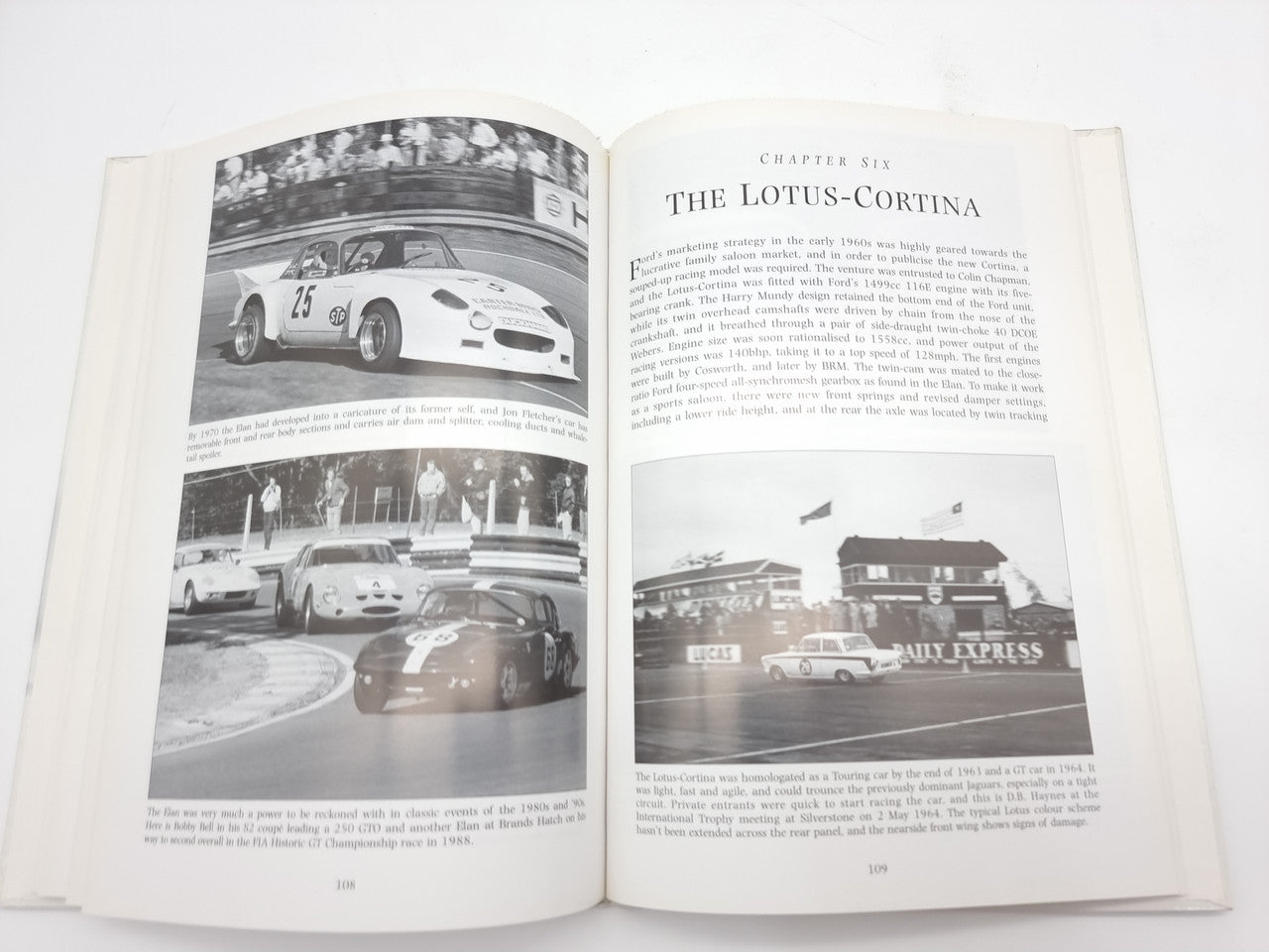 Open book spread with vintage race car photos and headings on printed pages