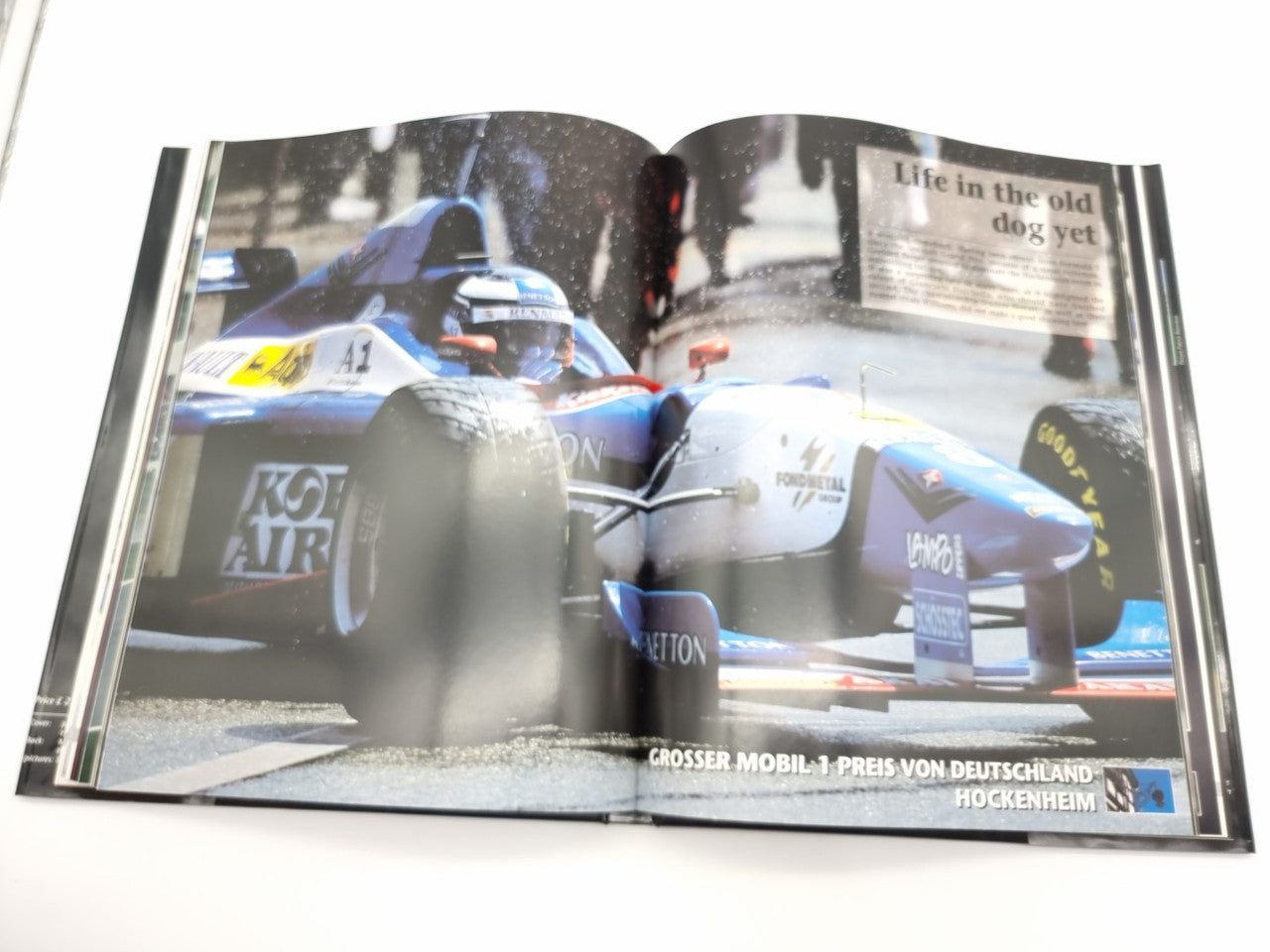 Formula 1 yearbook open spread showing race car close-up on the page