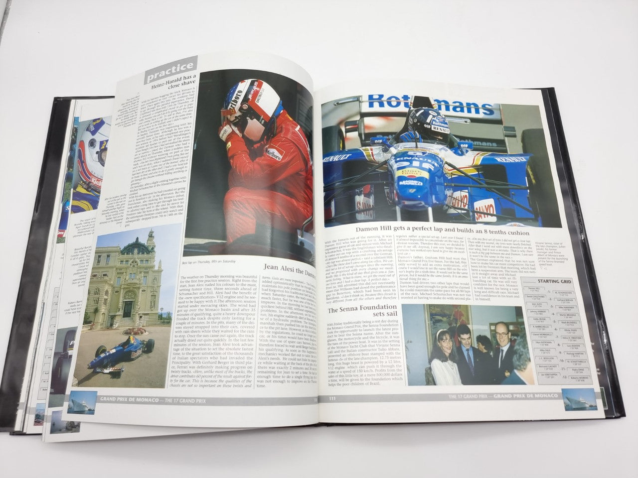 Formula 1 yearbook with open pages showing race photos and columns of text