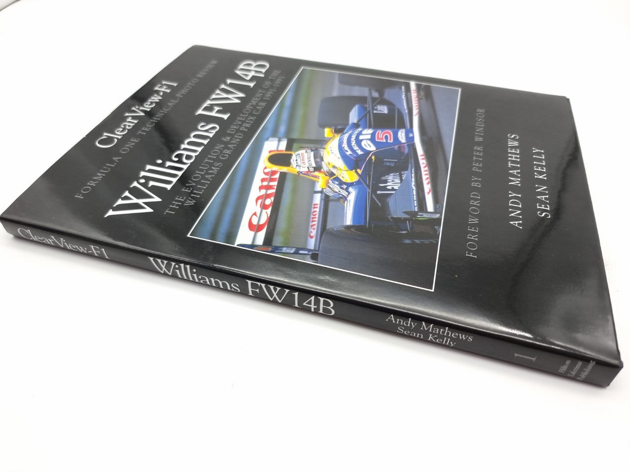 Race car history book with dark cover, car photo panel, and title text on front