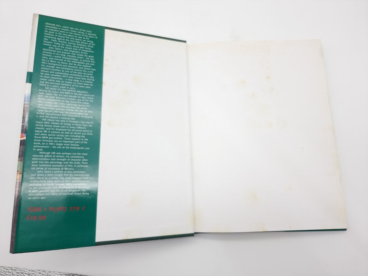 Open motorsport book with green text panel on the left page