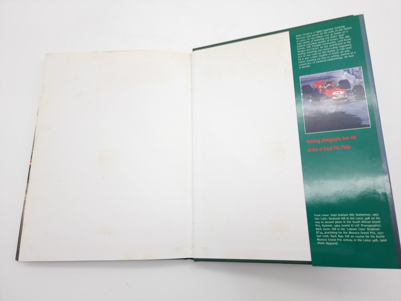 Open motorsport book with green text panel on the right page
