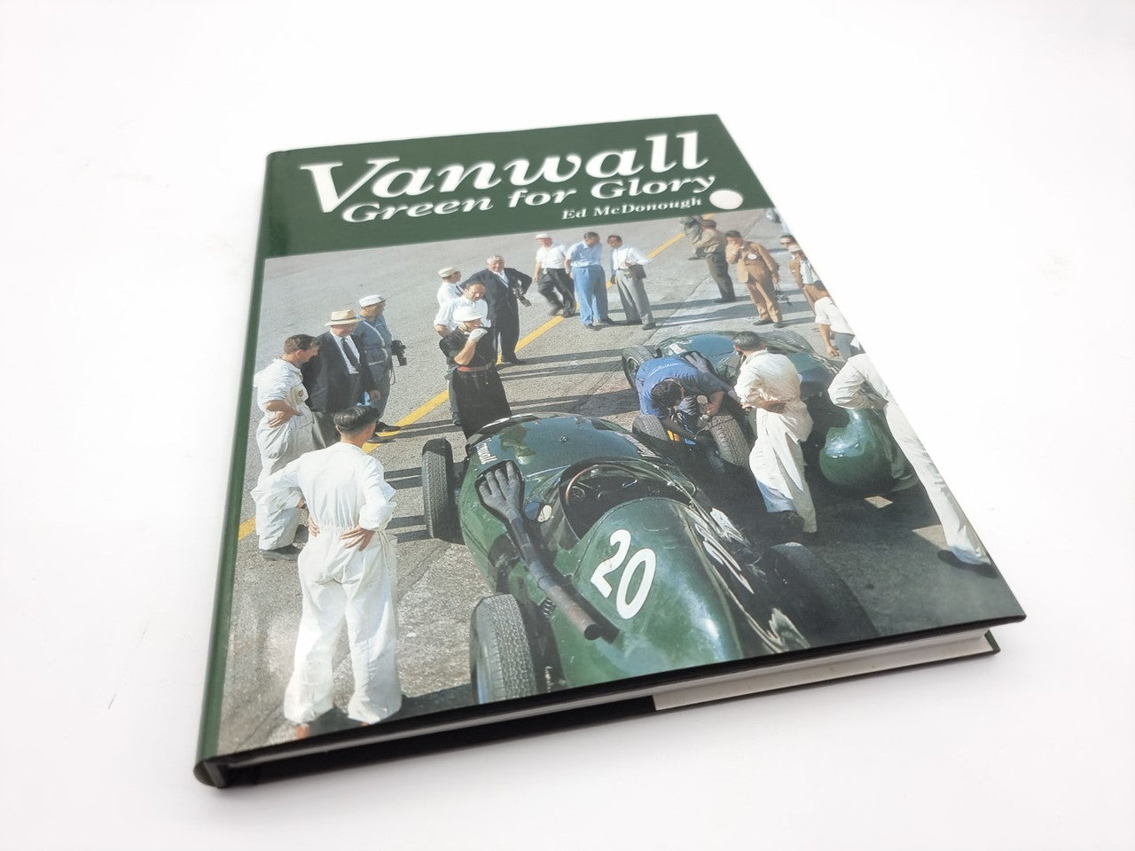 Green racing book cover with car numbered 20 and people on track