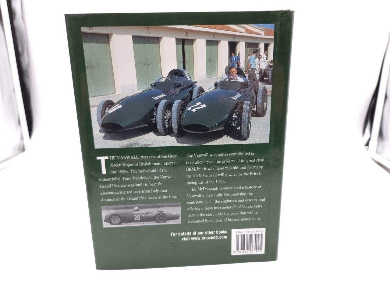 Green back cover of a racing book with car photo, text, and barcode