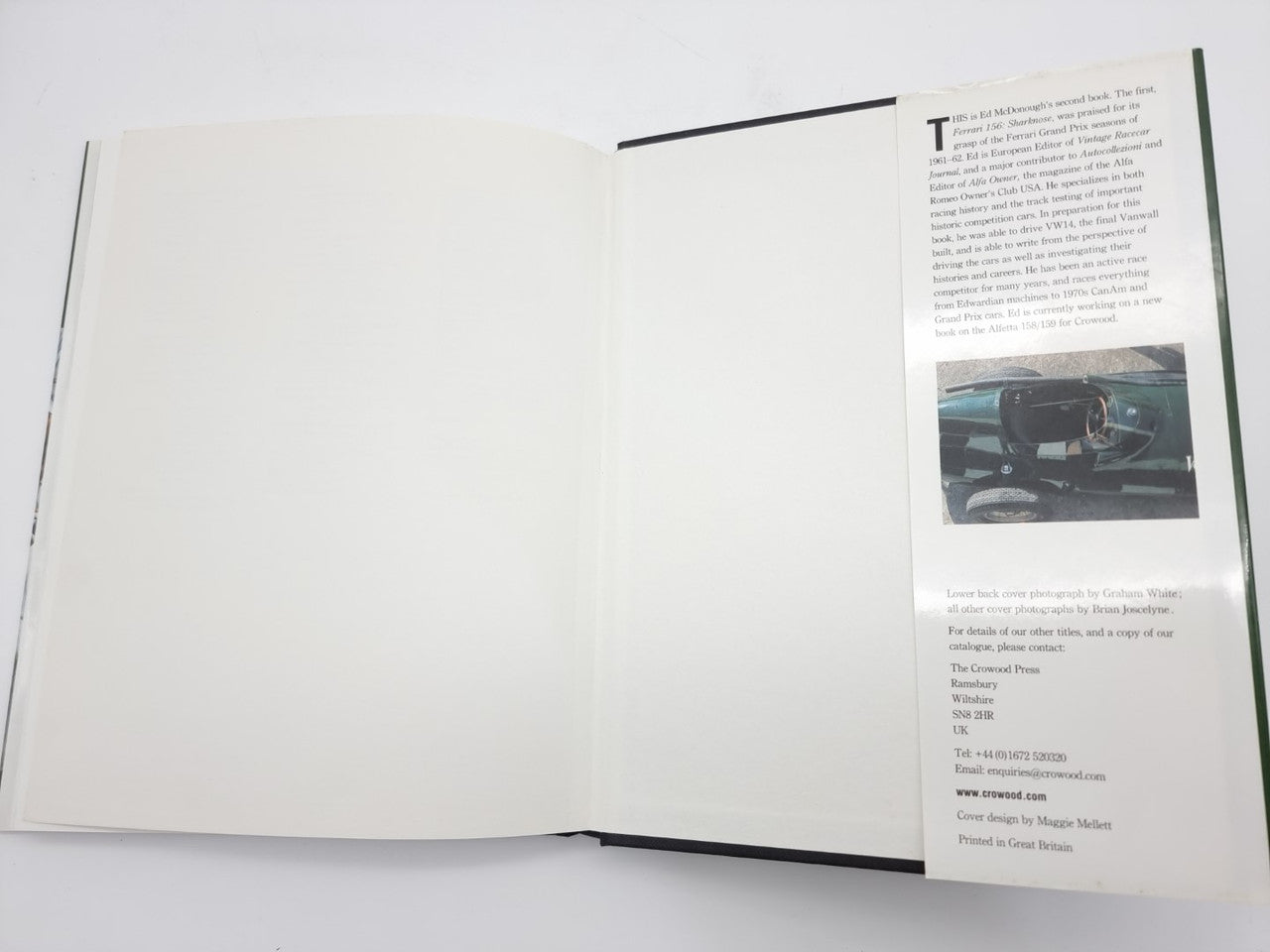 Open motorsport book with mostly blank spread and narrow side text panel