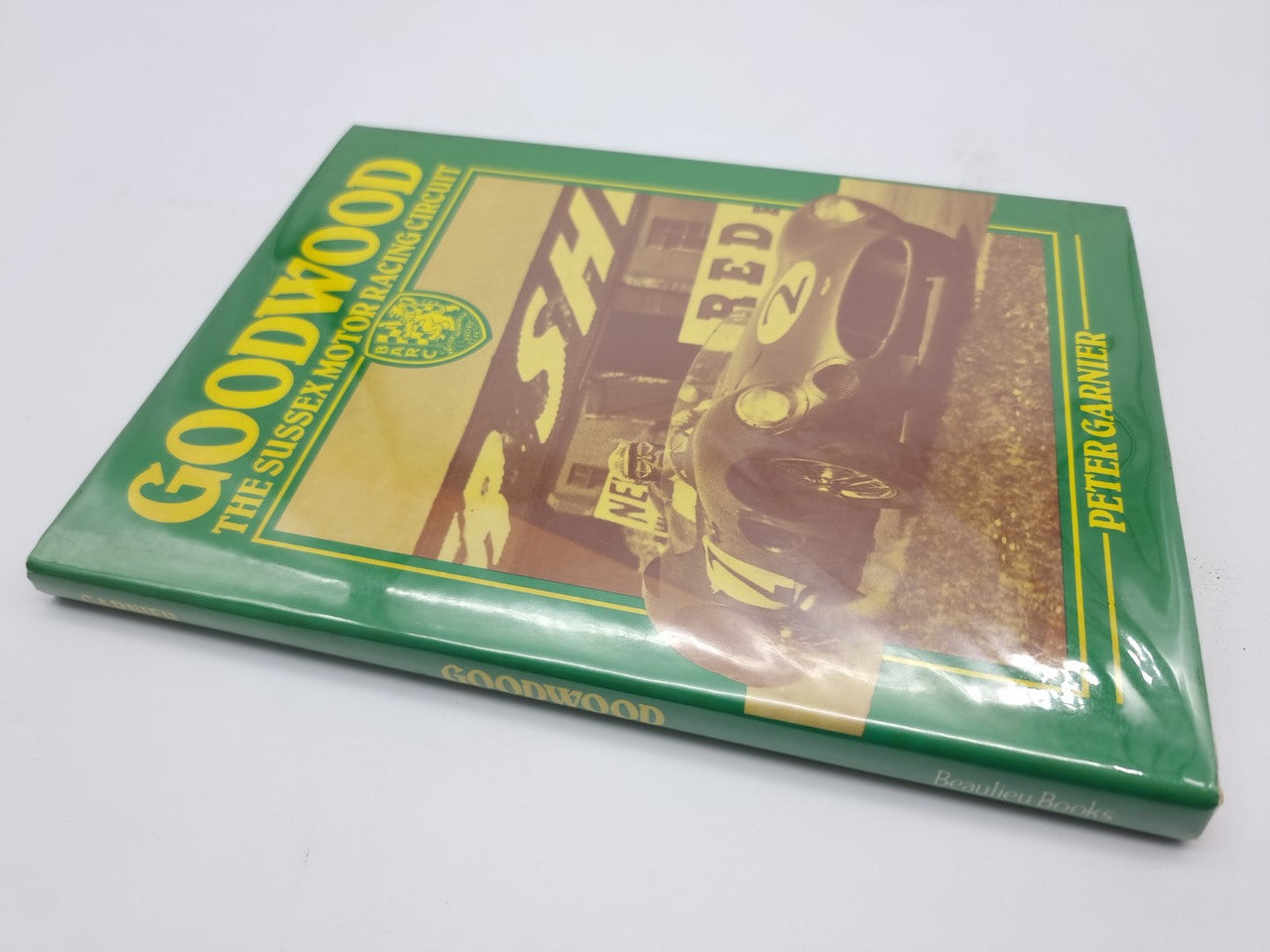 Hardcover book with green illustrated front cover, racing car photo and title text