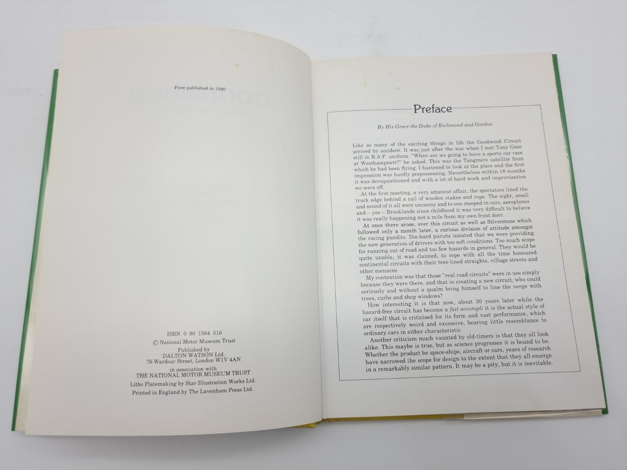 Hardcover book opened, blank left page and preface page on right, green page edges
