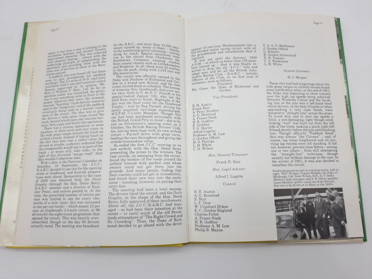 Open hardcover racing history book with columns of text and a small photo inset.