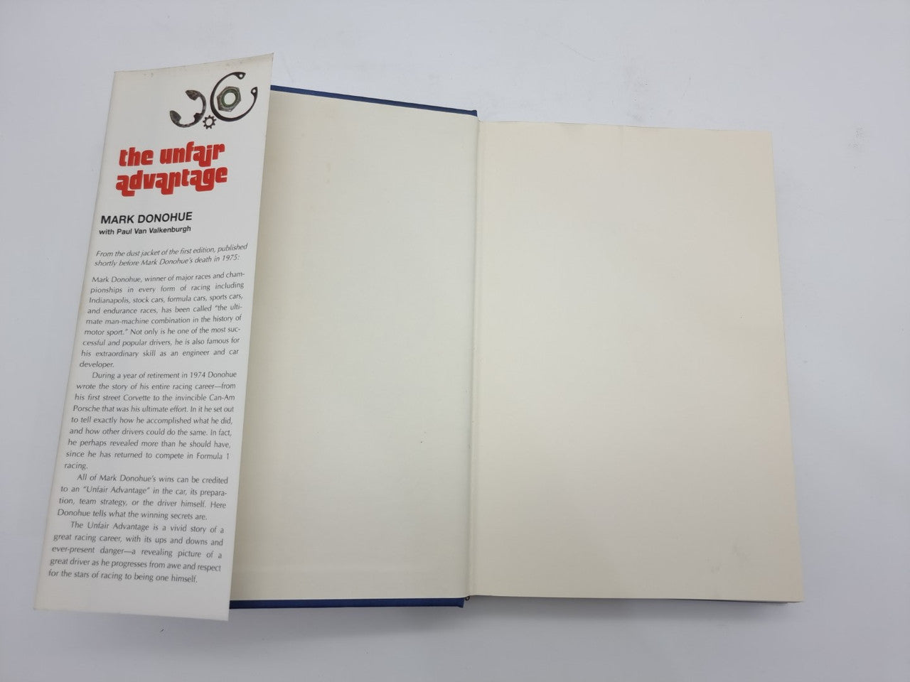 Hardcover book open; left page with title and author text, right page blank