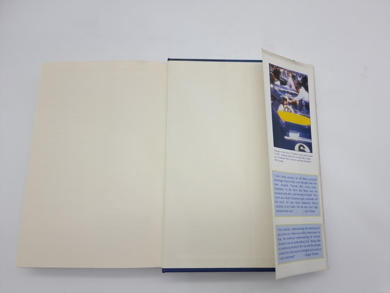 Hardcover book open to blank pages with blue spine and paper insert