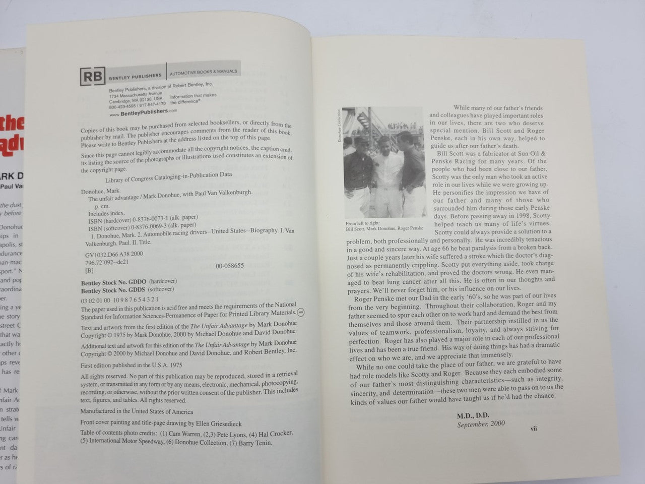 Hardcover book open to two text pages with headings and black-and-white photos