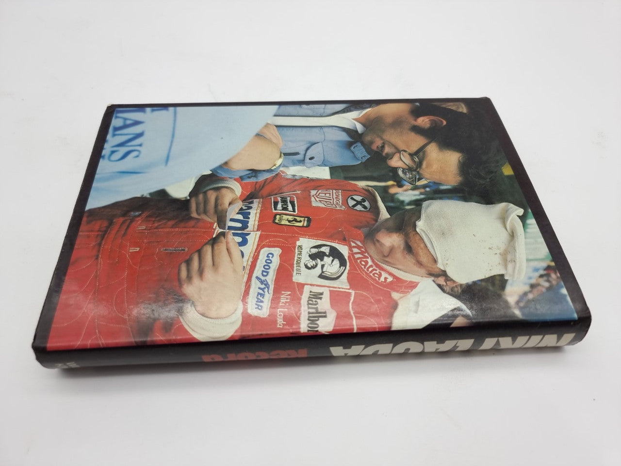 Closed hardcover book with racing photo cover and dark border.