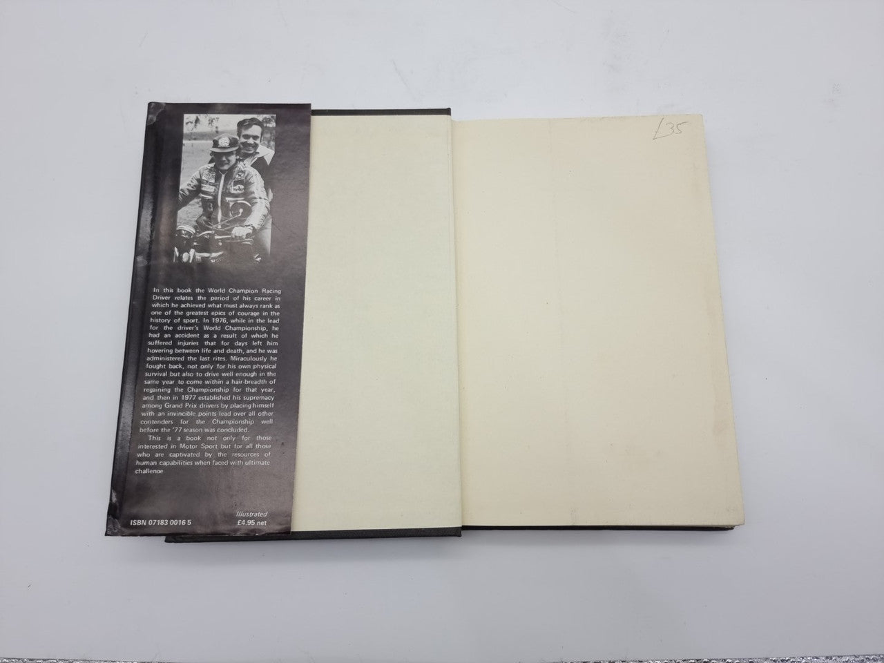 Opened hardcover book with cream pages and a dark vertical photo-and-text panel.