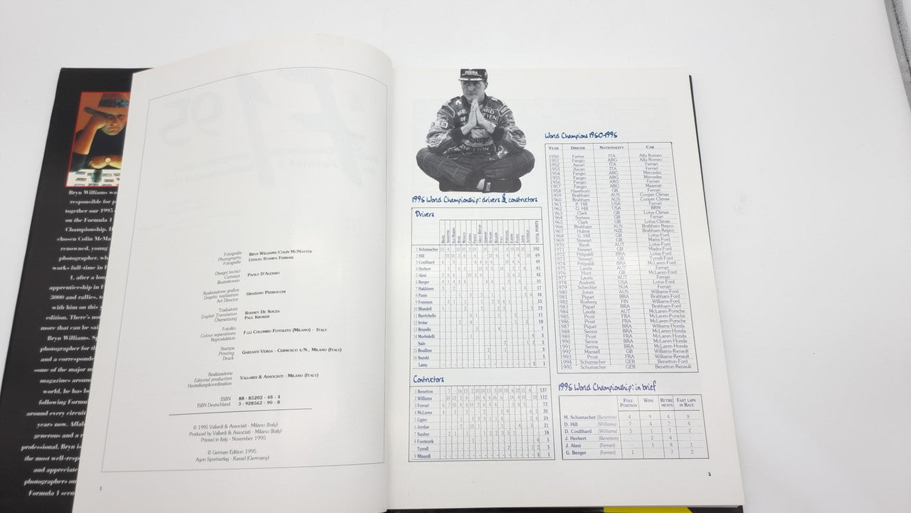 Photographic review book open pages with text, photos, and tables.