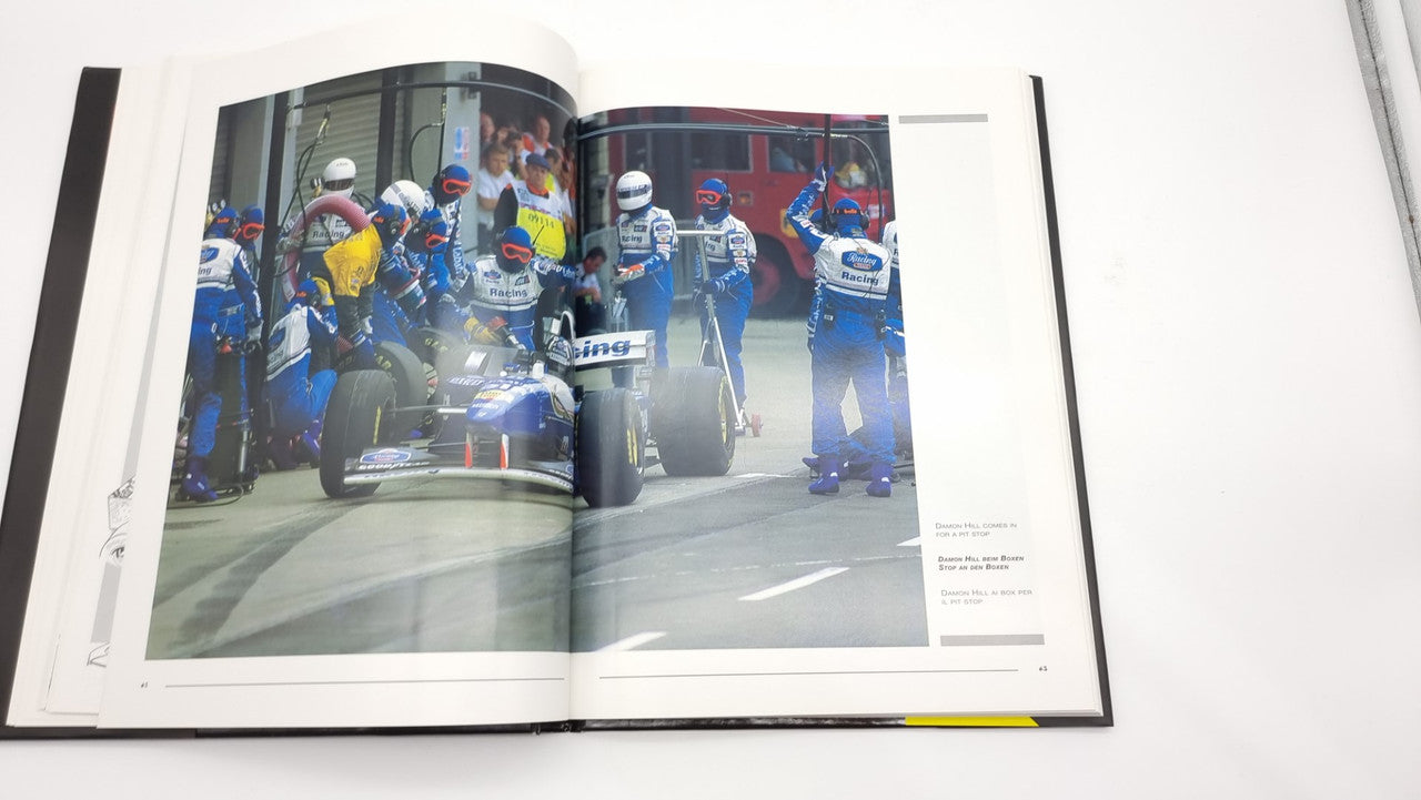 Photographic review book open pages with group photo of race car team.