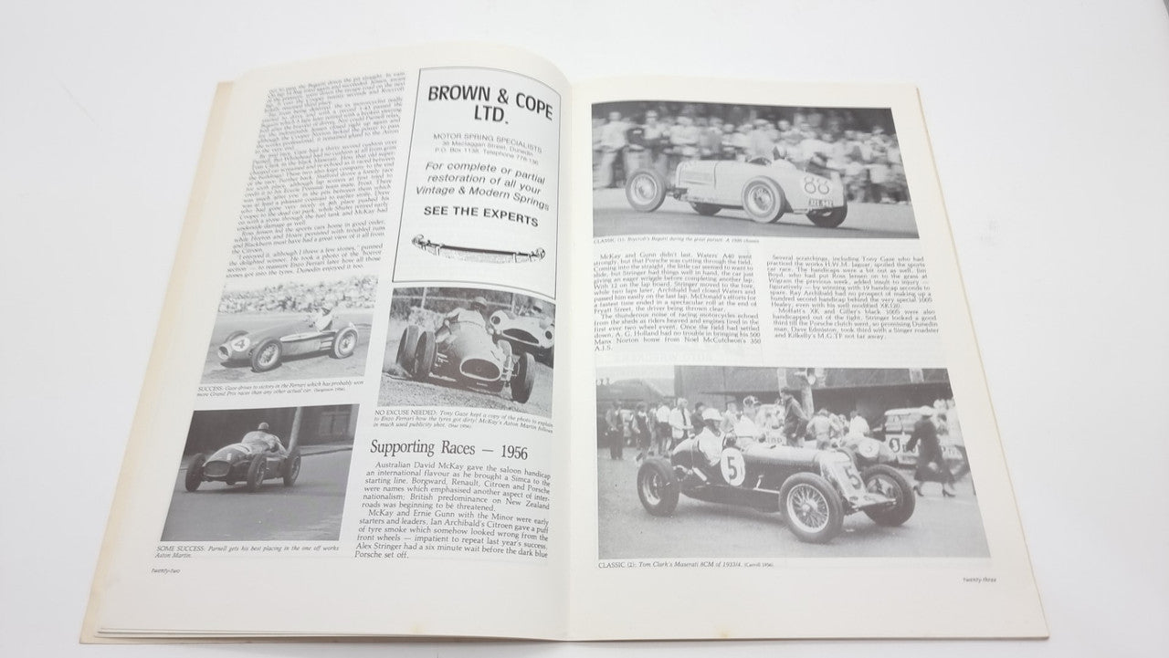 Open race-history book spread with racing photos, headlines, and dense text
