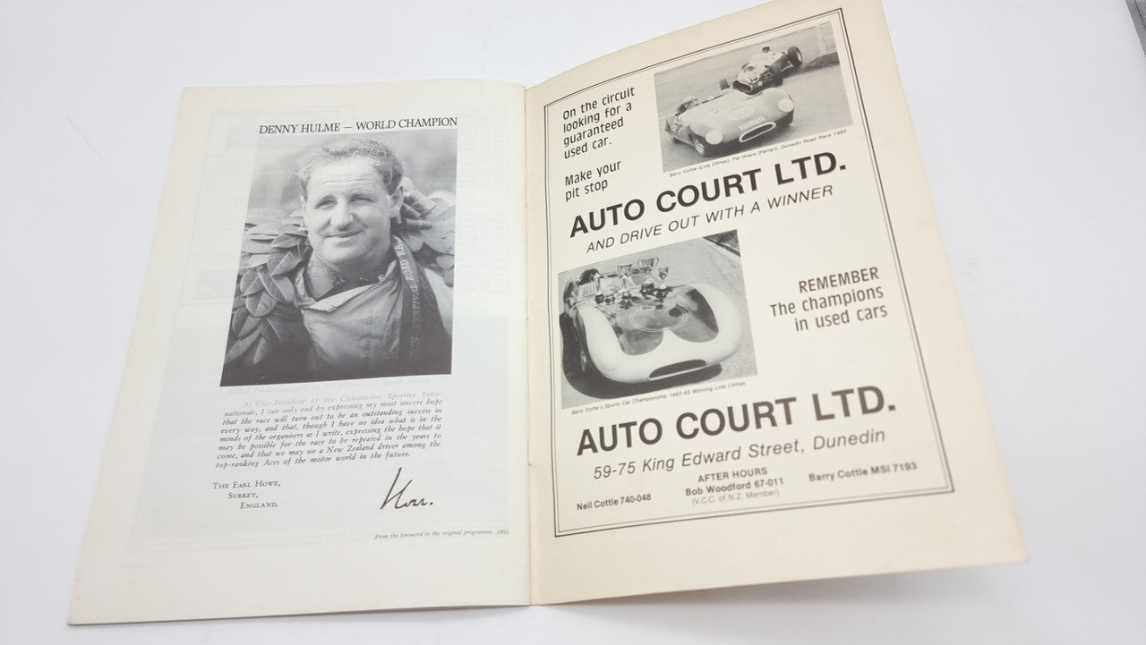 Open race-history book spread with a portrait and vintage car advertisement