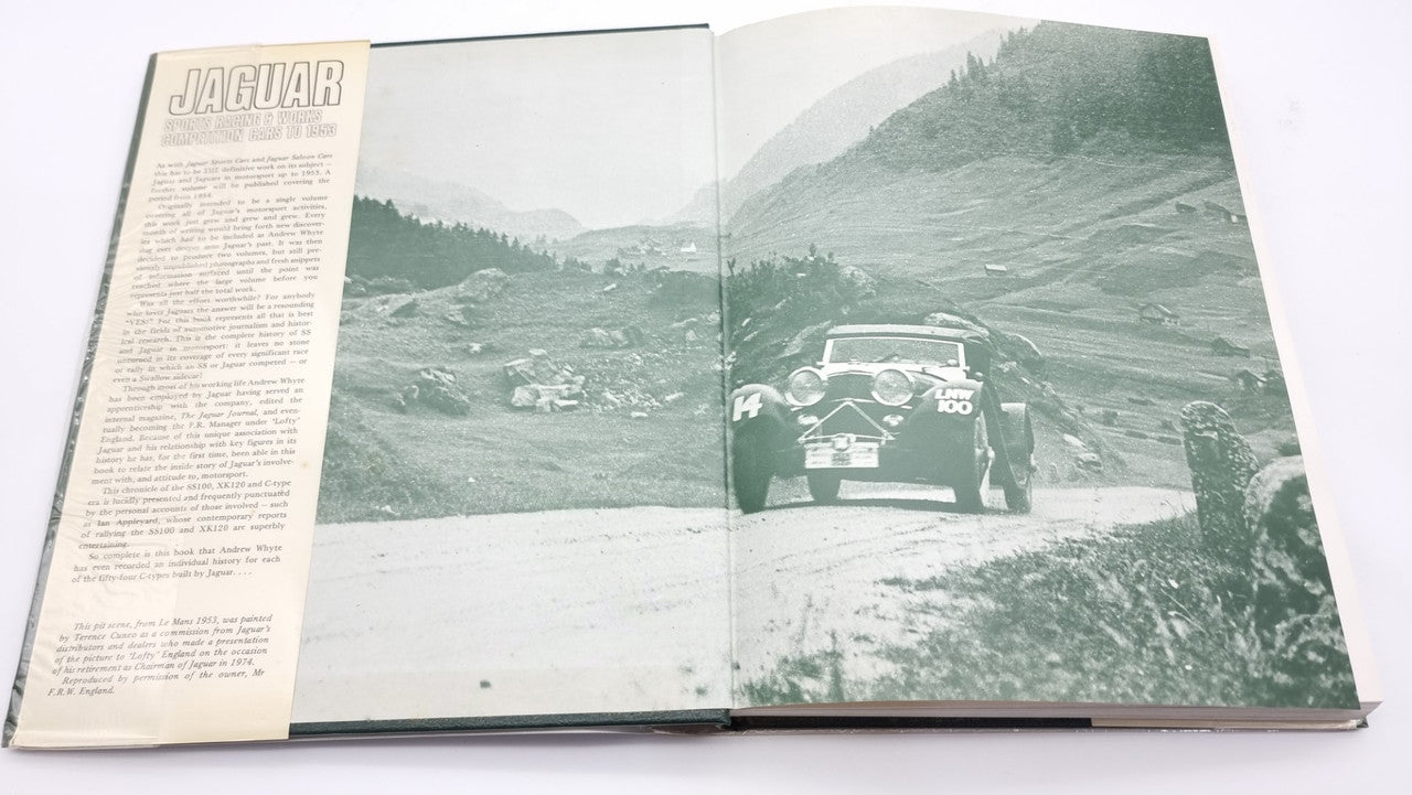 Jaguar sports racing book, open pages with car photo on a mountain road and printed text