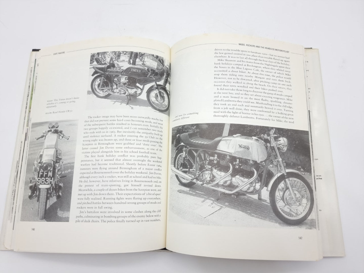 Open paperback book spread with close-up motorcycle photos and paragraphs of text