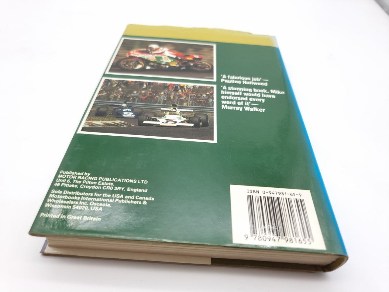 Closed book with green back cover, photo collage, and barcode label