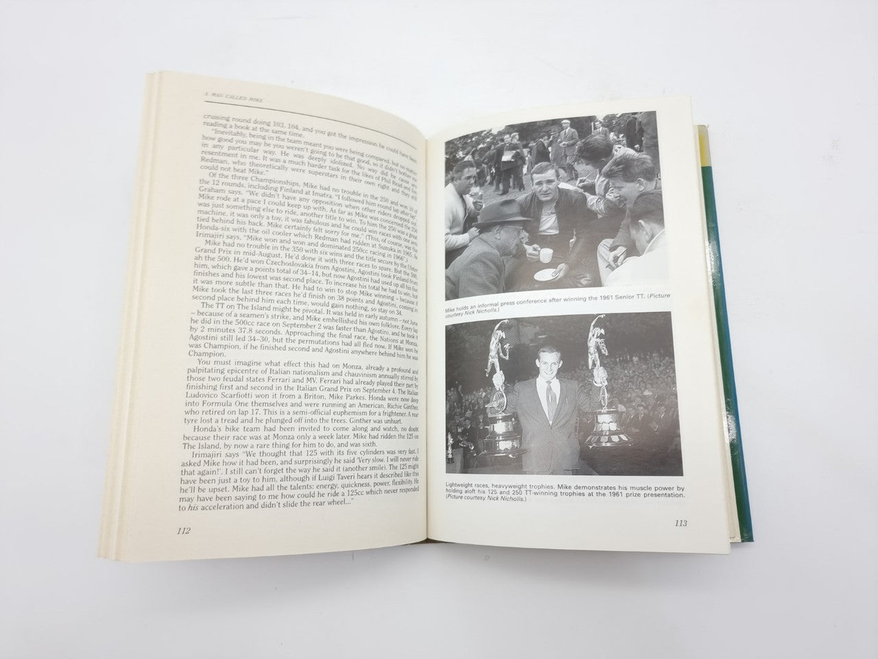 Book open to black-and-white photo pages with paragraphs on the left
