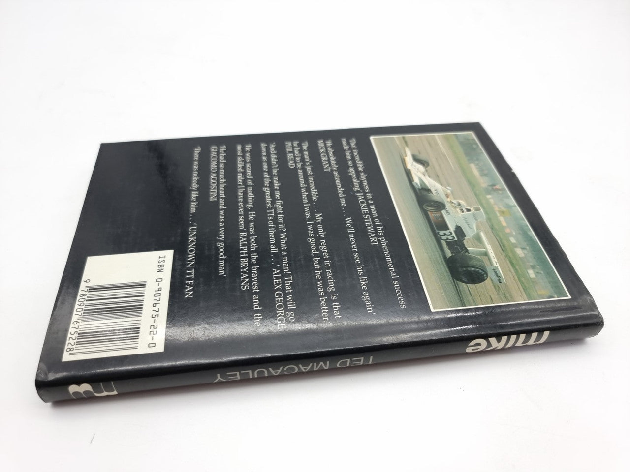 Hardcover book back cover angled, with barcode, text columns, and photo inset.
