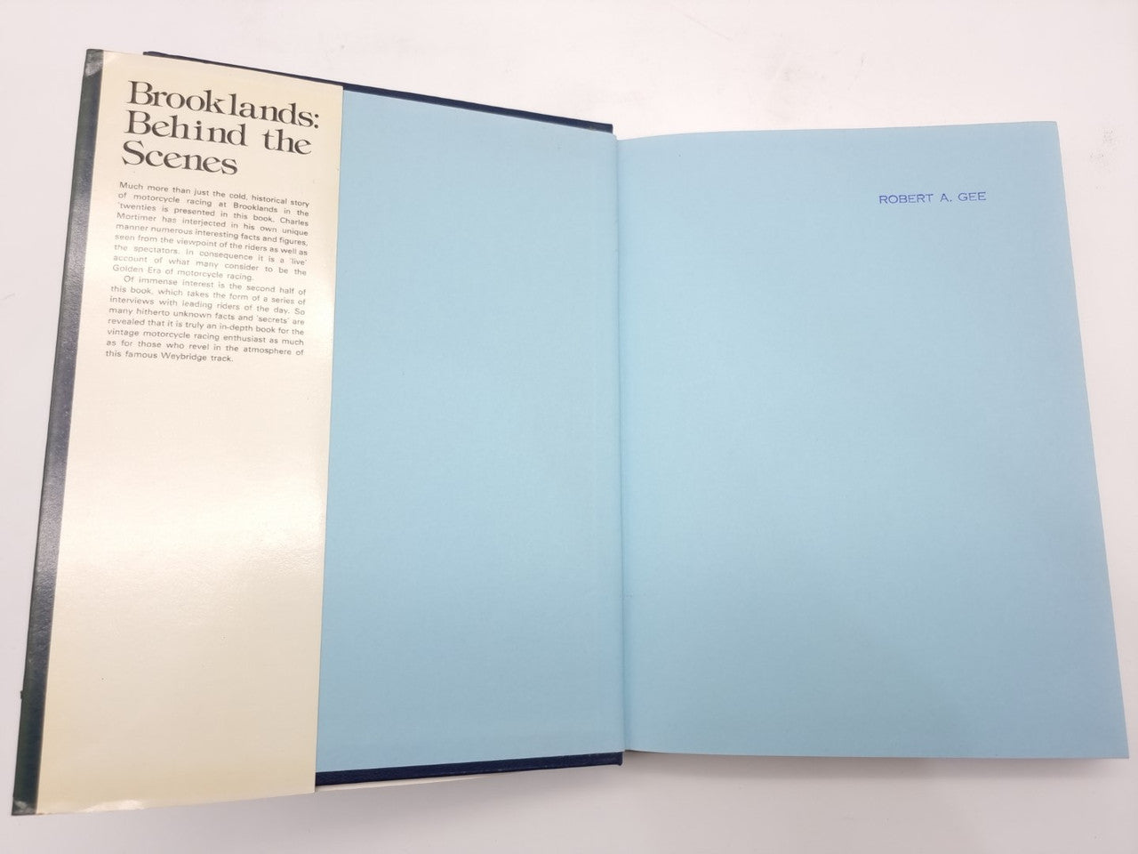 Open book with left page titled “Brooklands: Behind the Scenes” and right blue page.