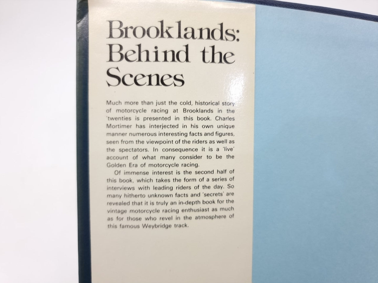 Book page close-up with large heading “Brooklands: Behind the Scenes” and paragraph text.