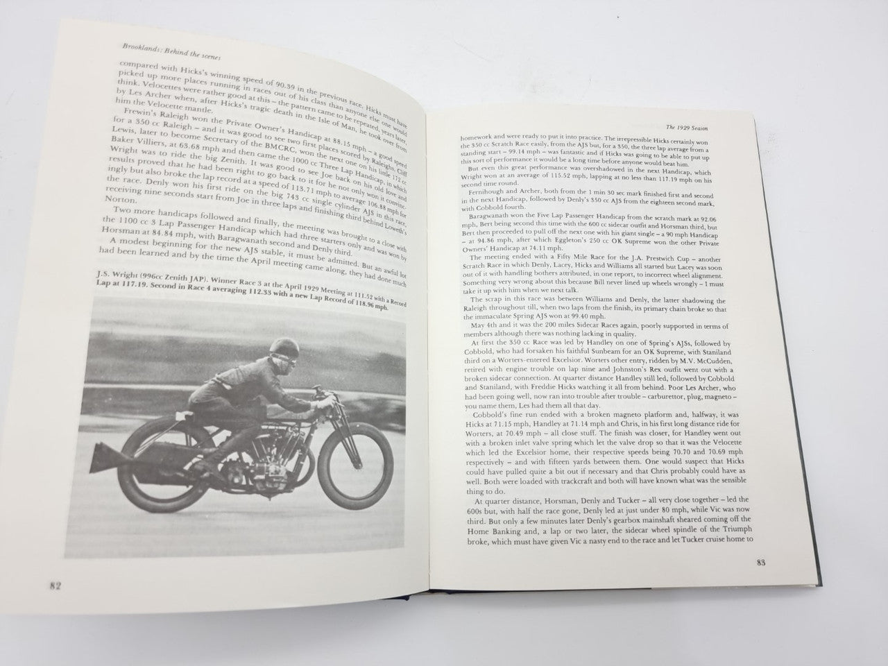 Open paperback book with printed text and black-and-white motorcycle photo