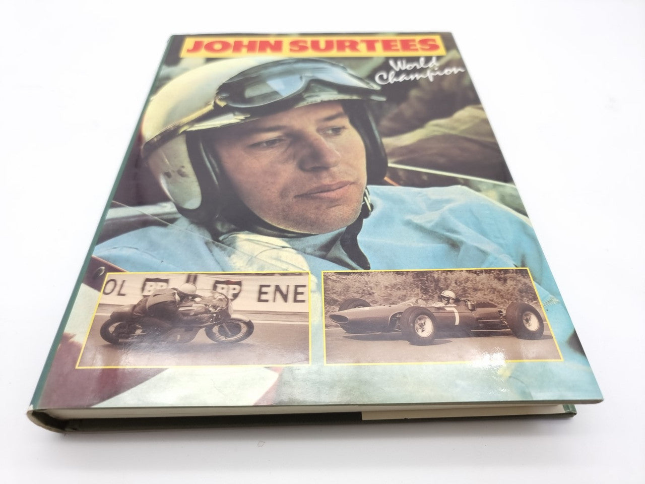 John Surtees World Champion book front cover with helmet portrait and race photos