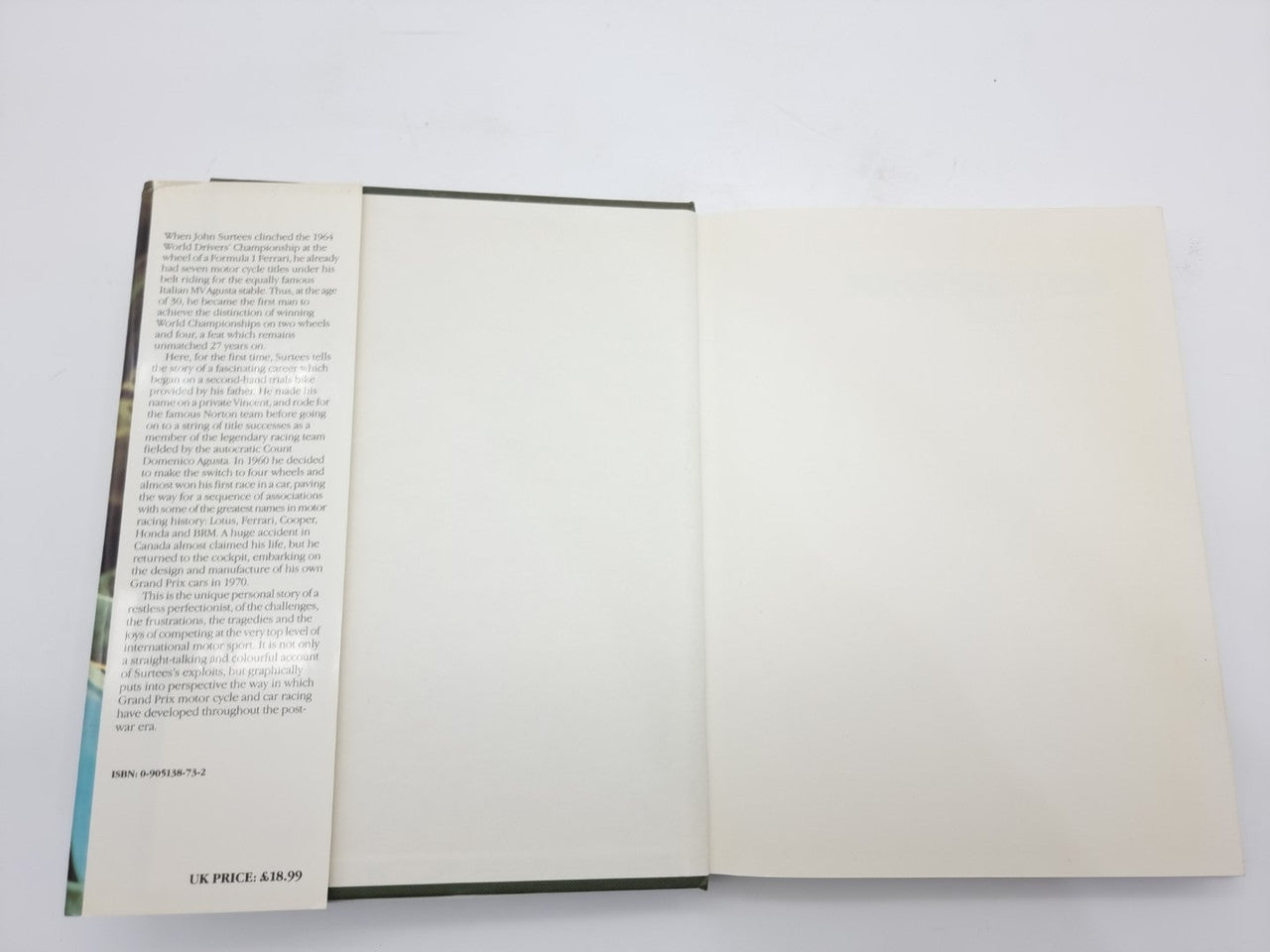John Surtees World Champion book open to mostly blank pages with text on left