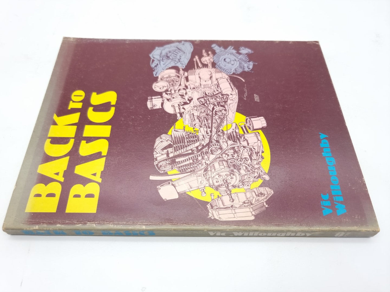 Maroon paperback book cover with large yellow title text and engine diagram