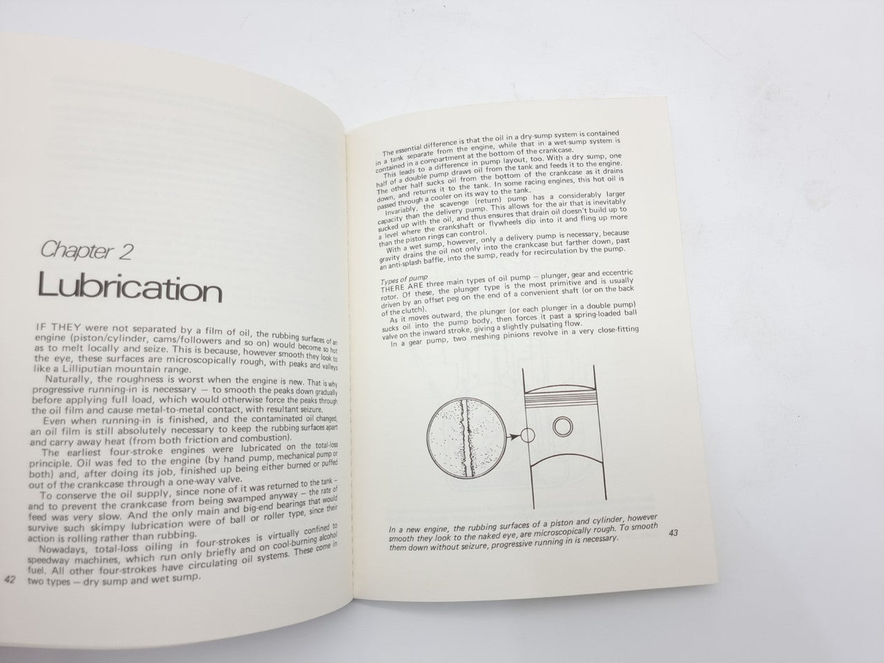 Open paperback book showing Chapter 2 Lubrication text and lubrication diagram