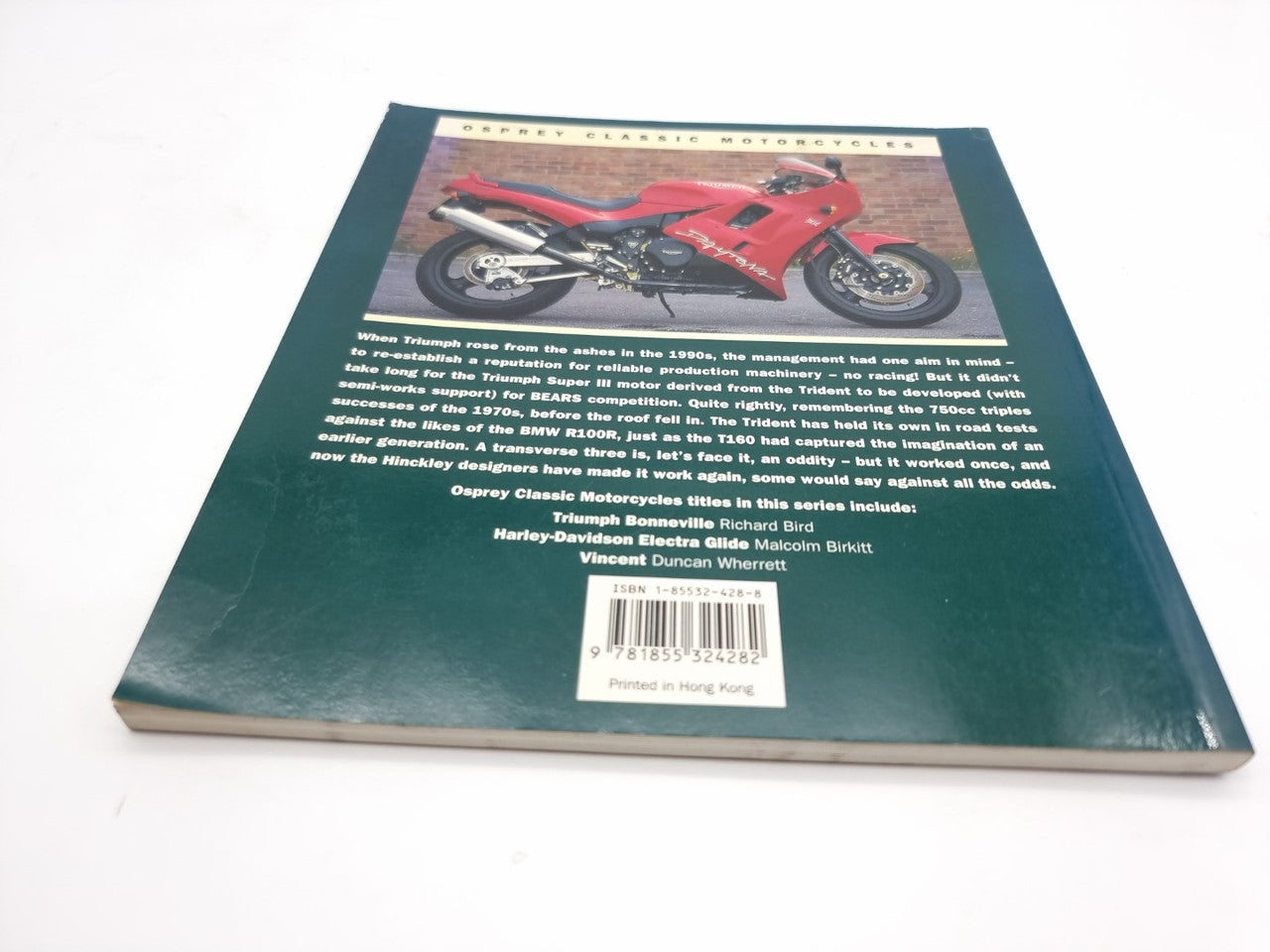 Closed hardback motorcycle photo book with a red motorcycle on the cover