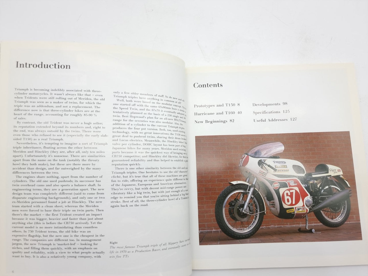 Open hardcover motorcycle photo book with “Introduction” and “Contents” pages and a bike photo
