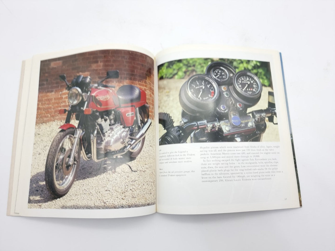 Open hardcover motorcycle photo book showing a red motorcycle and instrument gauges