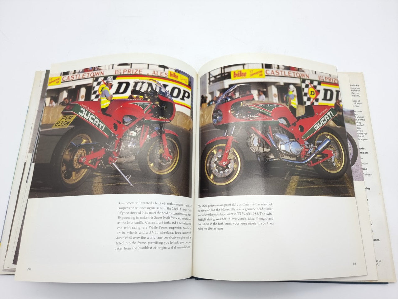 Open Ducati motorcycle history book with two pages of red race bike photos and text