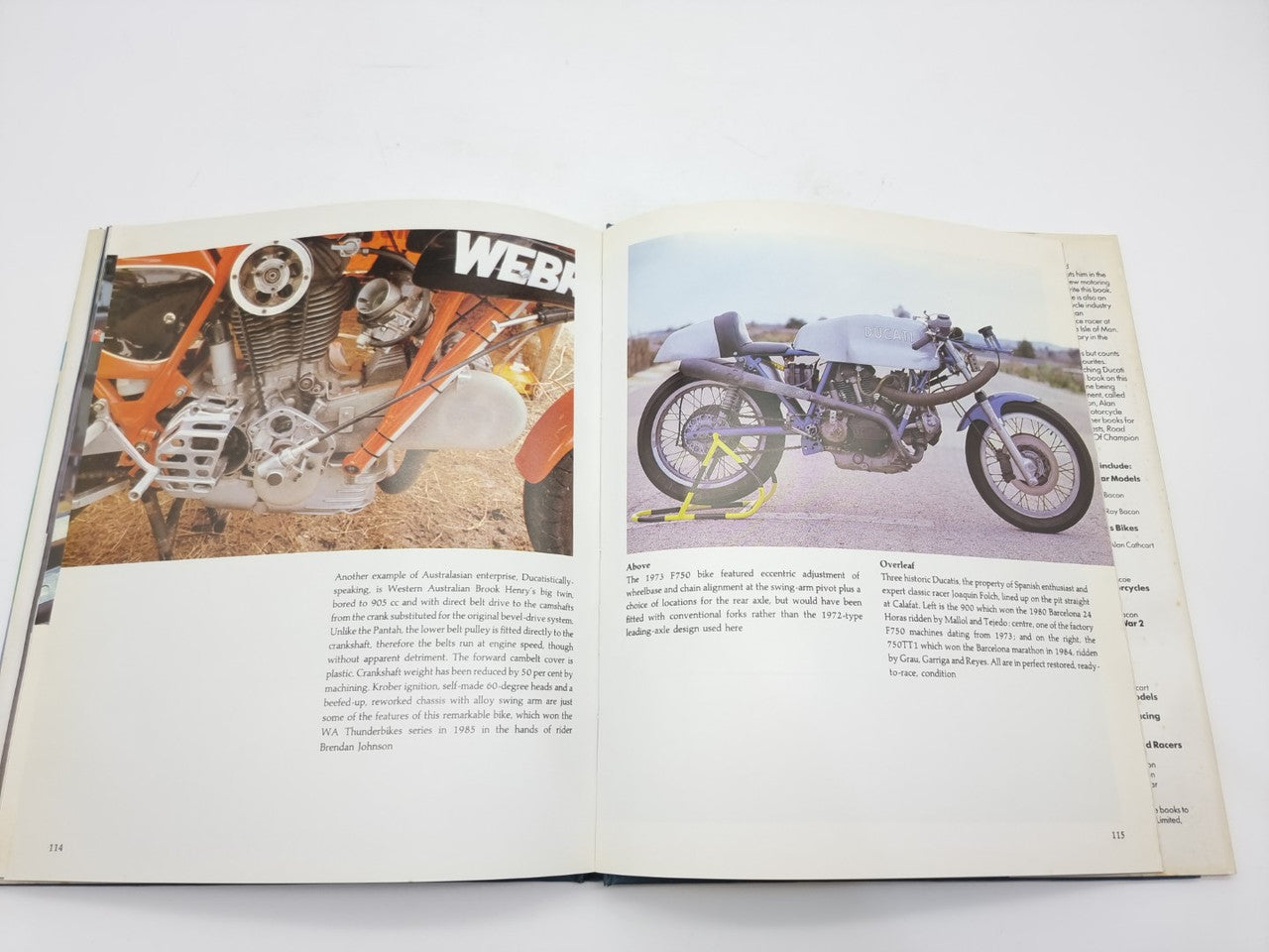 Open motorcycle history book with orange engine parts photo on left and blue bike photo